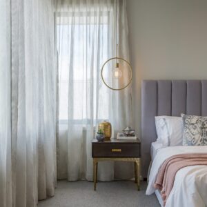 Sheer curtains following the corner of a bedroom