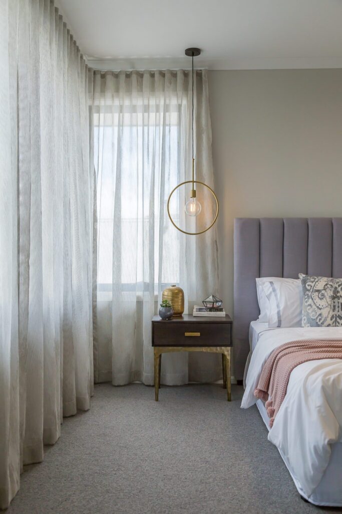 Sheer curtains following the corner of a bedroom